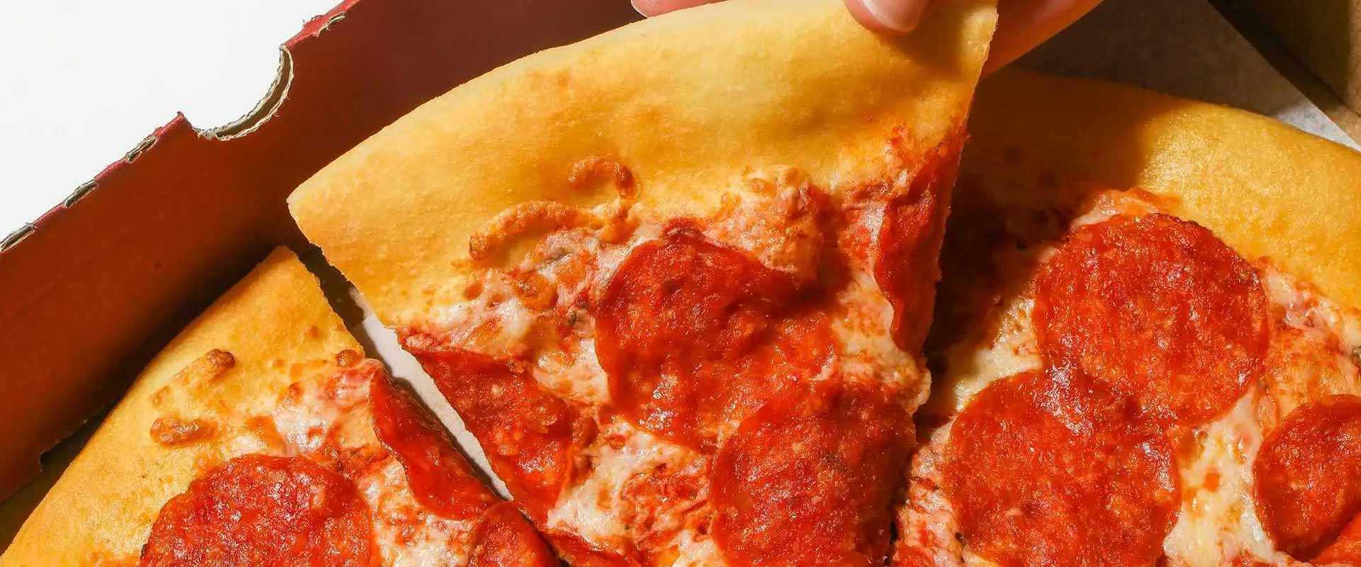 A slice of pepperoni pizza is pulled from the box at Curiosity Café.